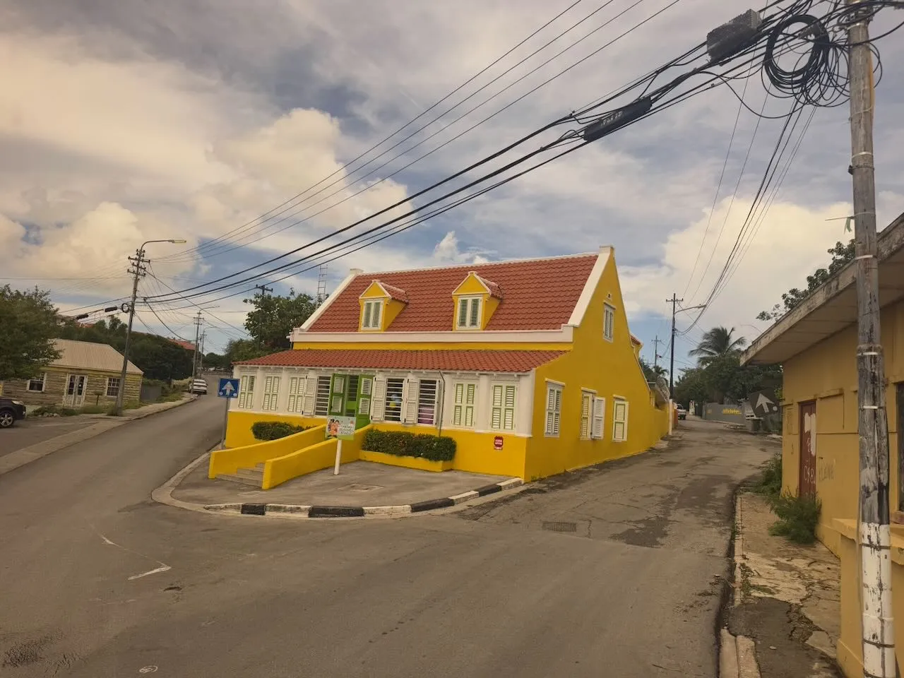 Yellow Dutch colonial house with orange tile roof on Curacao street